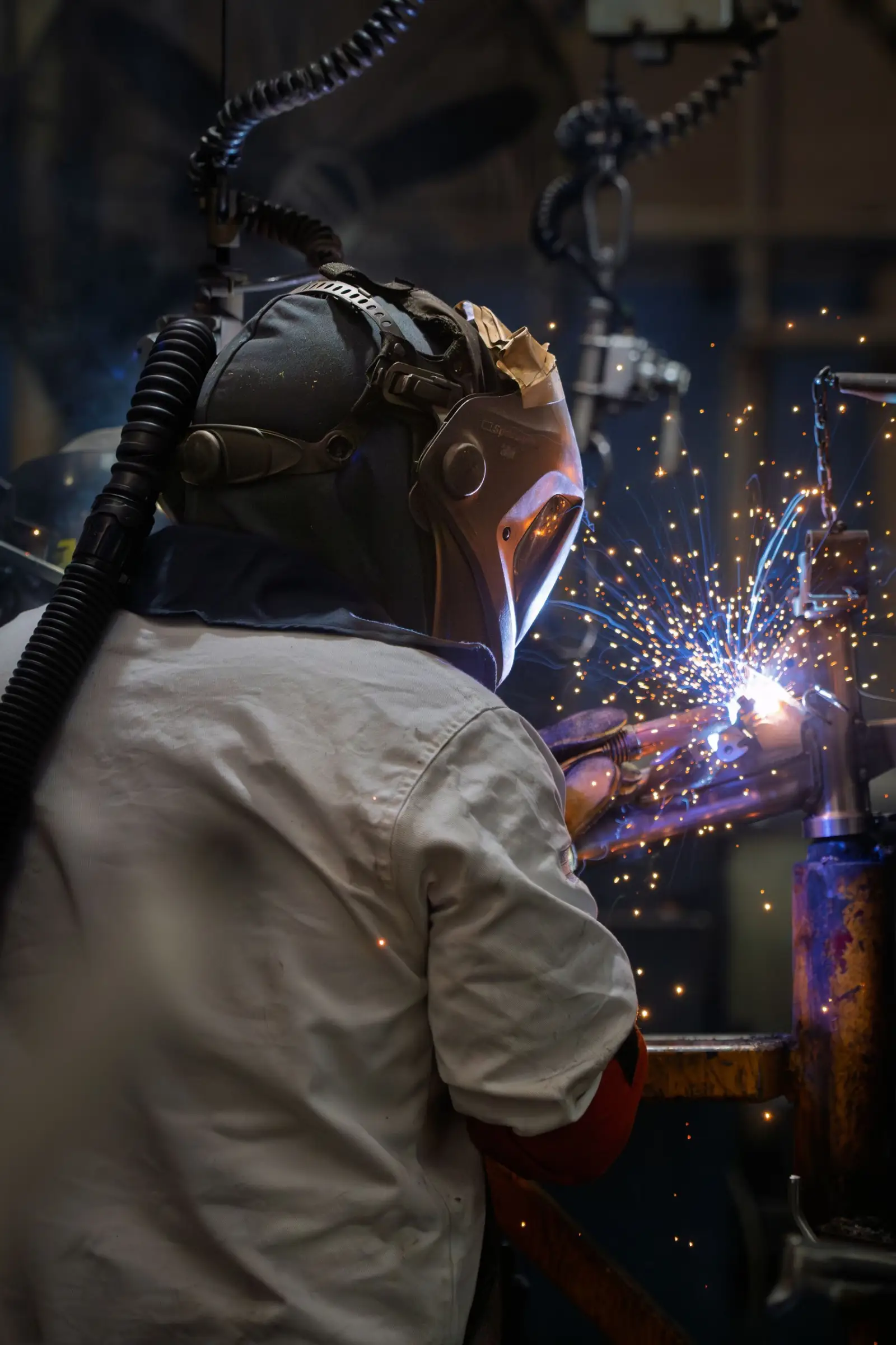 Welder mid weld with sparks flying